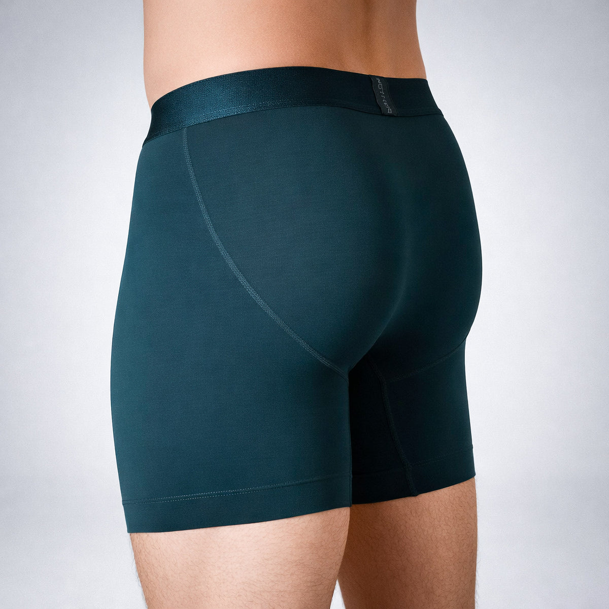 Nether Boxer Brief in Forest - side angle on model showing rear panel contouring, curved seam design, and NETHER waistband logo placement