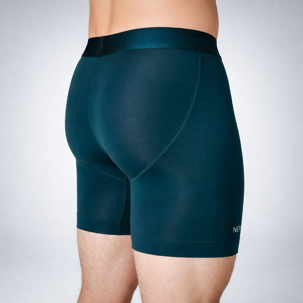 Nether Boxer Brief in Forest - rear quarter view on model showing Trail Grip silicone leg hem, NETHER leg branding, and ergonomic seam placement