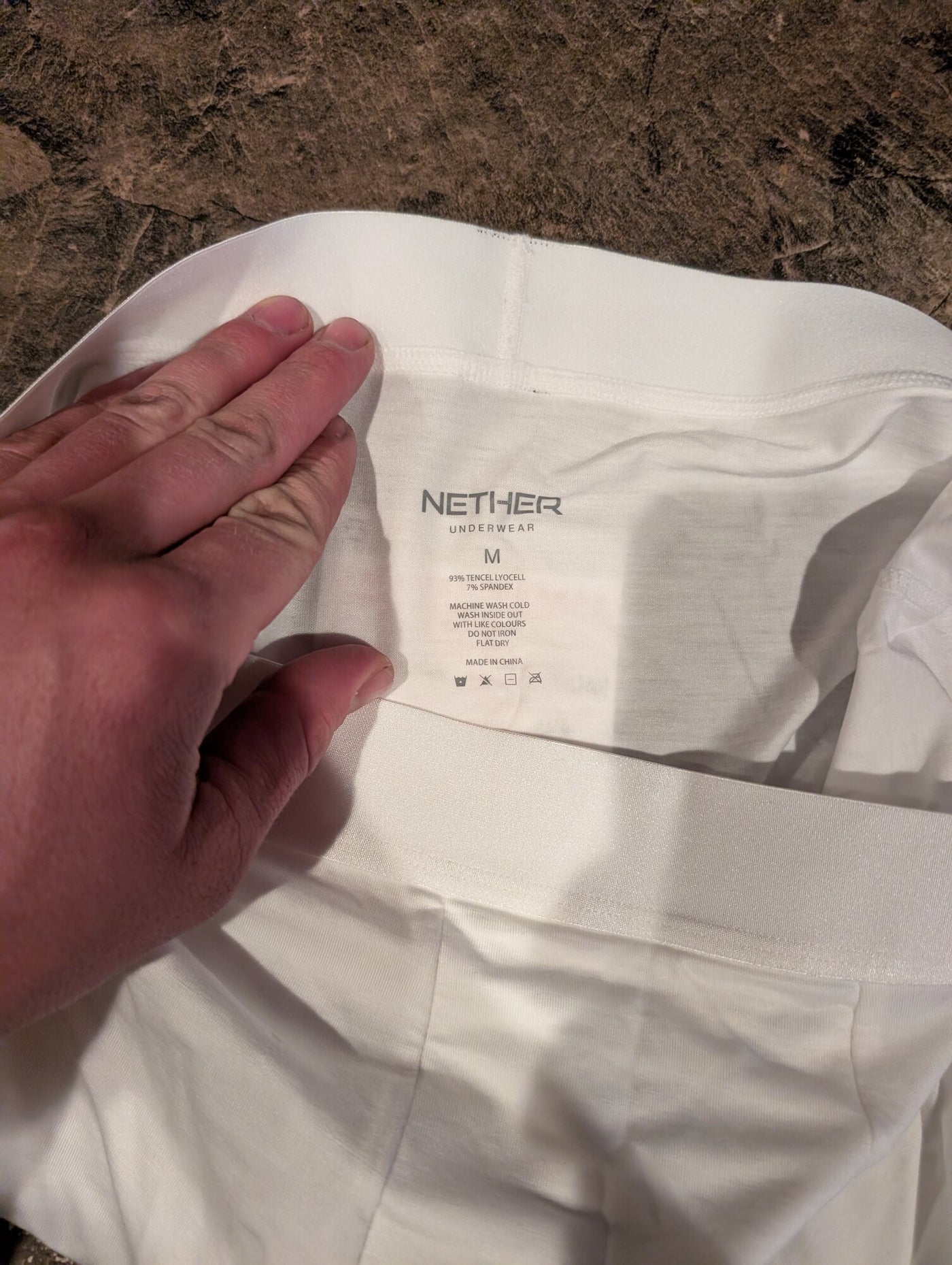 The care label inside a white Nether boxer brief reading 93% TENCEL Lyocell, 7% spandex, size M