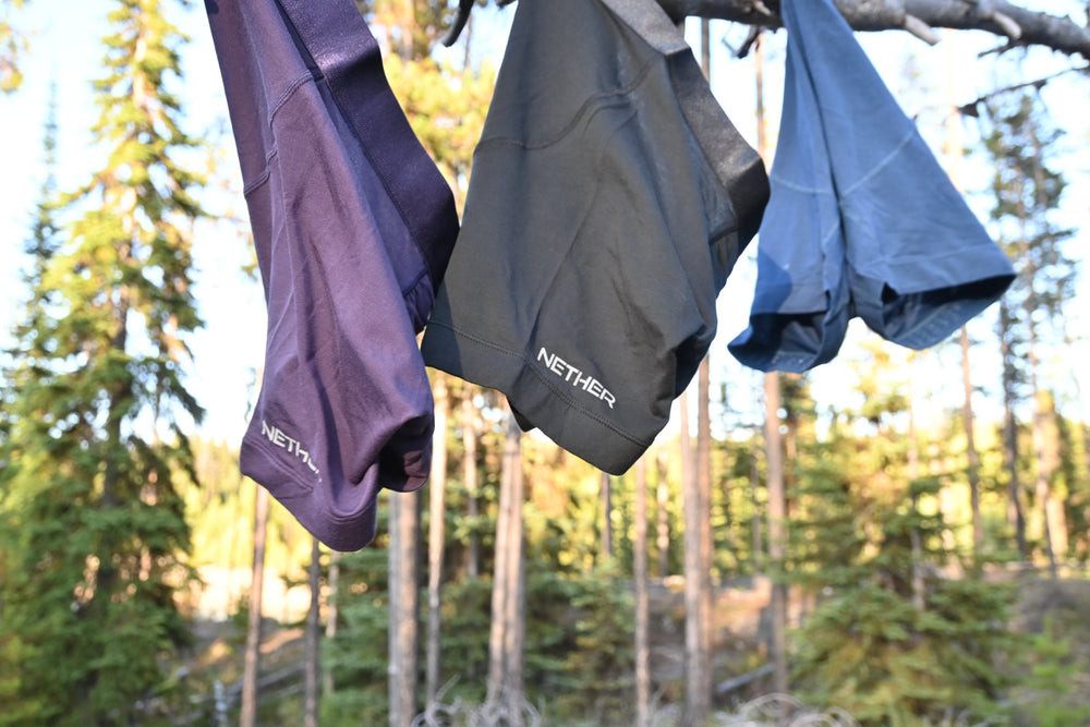 Roam Boxer Briefs in Storm, Midnight and Abyss hanging on a log in a forest