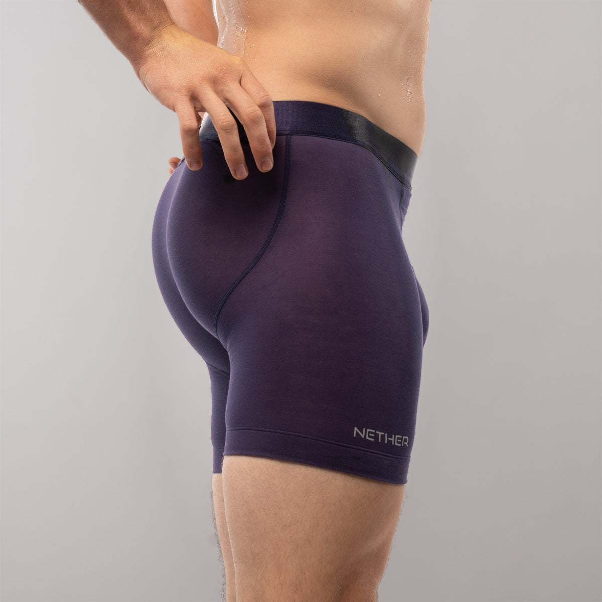 [Storm] Nether Roam Boxer Brief in dark purple, rear quarter view with the waistband held at the hip