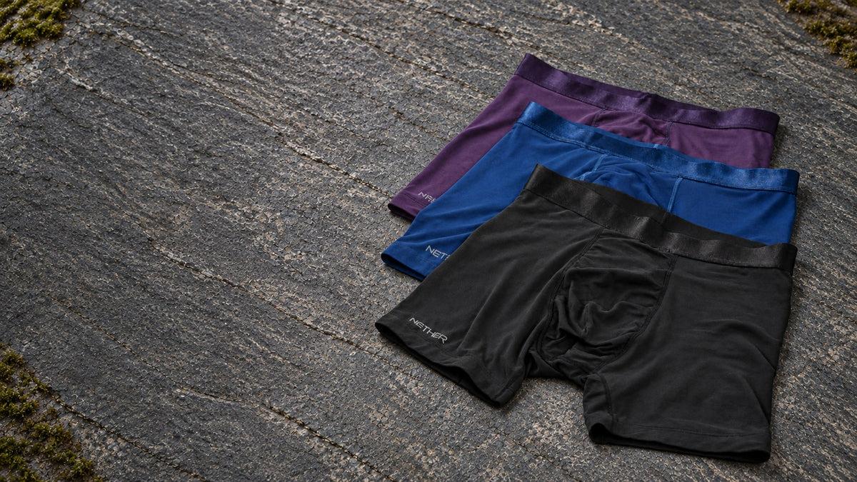 ROAM boxer briefs in Storm, Abyss and Midnight laid on natural grey stone, with space to the left.